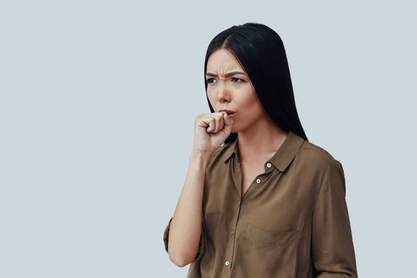 Frio e gripe. Ill jovem mulher asiática tosse enquanto de pé contra fundo cinza — Fotografia de Stock