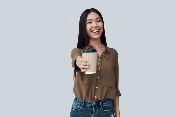 Café fresco. Hermosa mujer asiática joven mirando a la cámara y sonriendo mientras está de pie sobre fondo gris —  Fotos de Stock