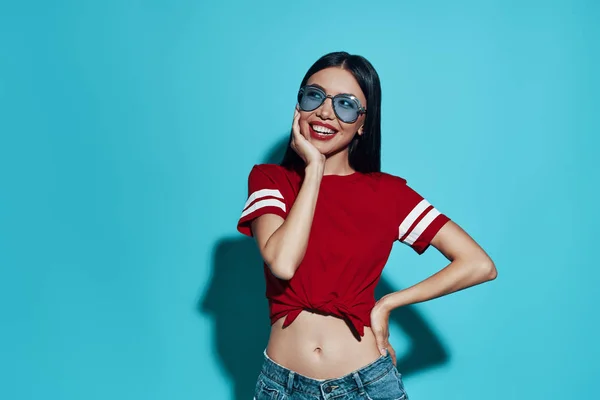 Young and beautiful. Attractive young Asian woman smiling while standing against blue background — Stock Photo, Image