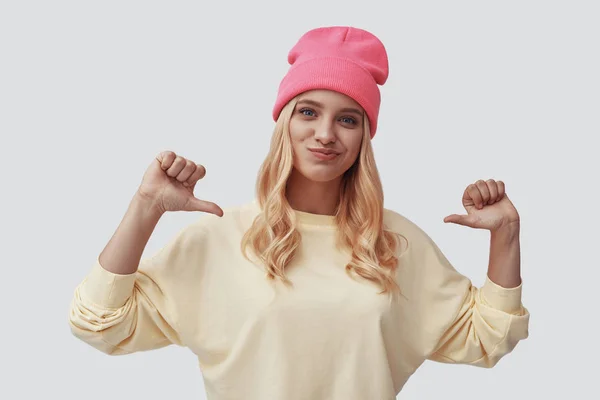 Jeune femme séduisante gestuelle et souriante debout sur fond gris — Photo