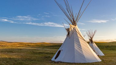 Two teepees representative of those used by the Blackfeet Indians on the Great Plains of Montana, USA. clipart