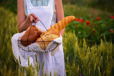 Bir kadın buğdaylı bir tarlada ekmek taşır. Bir kadının elinde sepetin içinde çeşit çeşit ekmek. Bir buğday tarlası olgunlaşıyor. Bir sepet ekmekle tarlada güzel bir gün batımı. Ekmek tarlada. 