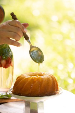 Tatlı olarak şurup dökülüyor. Delikli kek akçaağaç şurubuyla doldurulur. Bahçede çiçekli kek. Piknik