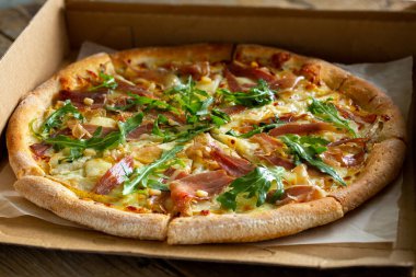 Kutuda pizza. Pizza. Peynirli, jambonlu, roka ve çam fıstıklı pizza. Evde lezzetli sıcak pizza. Abur cubur teslimatı..