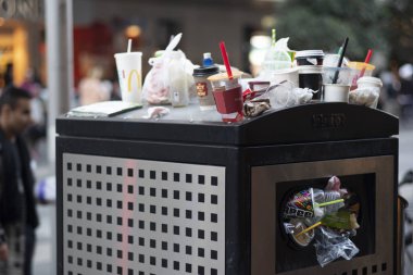 Plastik bardaklar, tek kullanımlık kahve fincanları, pipetler, vb... bir çöp kutusunda