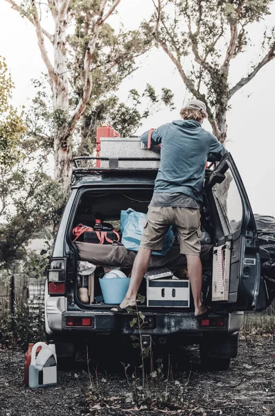 Un mochilero rubio y viajero en solitario comprueba su 4X4 antes de un viaje en carretera — Foto de Stock