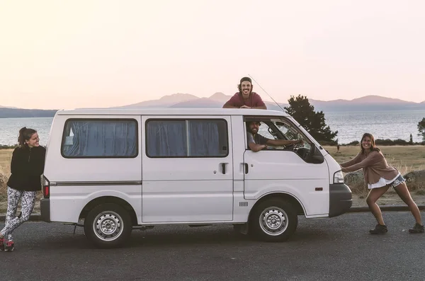 Cuatro compañeros de viaje disfrutan del momento en su camioneta blanca mientras viajan por todo el mundo — Foto de Stock