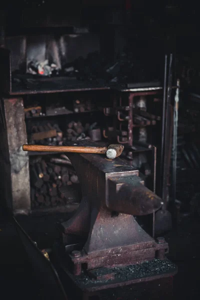 Een hamer op een oude school smederij. Een donkere vibe foto van een traditionele smederij — Stockfoto