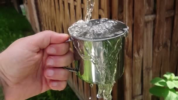 水晶清水倒入金属杯在手慢动作 节水概念 营地和生存 — 图库视频影像