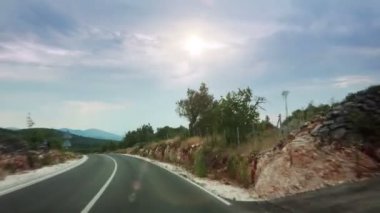 Dağlarda dolambaçlı bir yolda araba sürmek. Ön camdan görünüm. 