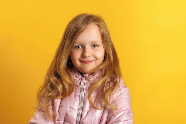 Retrato de uma menina bonita em uma jaqueta em um fundo amarelo. Conceito de outono e inverno . — Fotografia de Stock