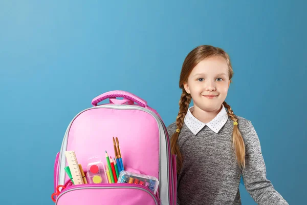 Primo piano ritratto di bambina studentessa con zaino su sfondo blu. Torniamo a scuola. Il concetto di istruzione . — Foto Stock