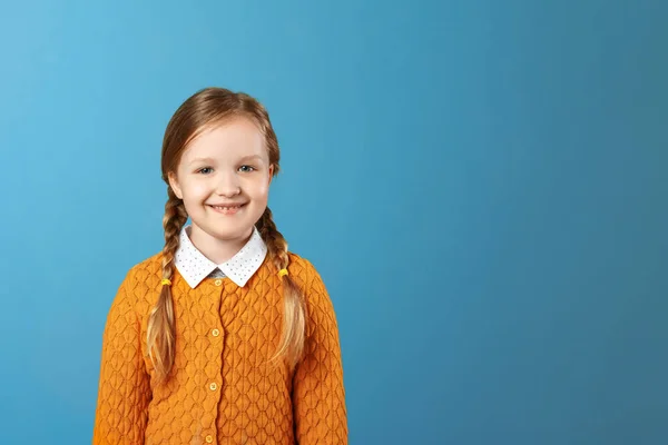 Closeup portrét malé dívčí dívky. Hezké dítě ve žlutém svetru na modrém pozadí. Kopírovat místo — Stock fotografie