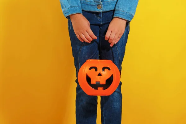 A child is waiting for candy with a bucket of pumpkin jack lantern. Halloween concept — Stock Photo, Image