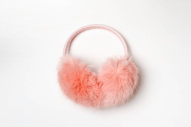 Beyaz arka planda yumuşak, pembe kulaklıklar.