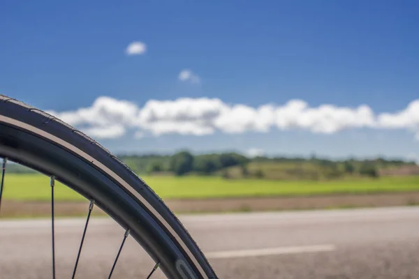 在开阔的风景前的道路上的自行车轮子 — 图库照片
