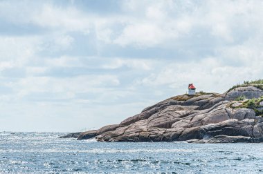 Güneşli bir uçurumda küçük bir seyir ışığı.