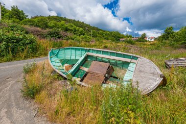 Yaşlı, ahşap balıkçı teknesi çimenlerde yatıyor..