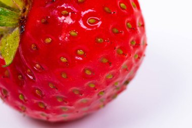 Beyaz arkaplanda bir çileğin makro resmi.