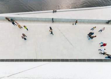 Beyaz beton bir yolda yürüyen insanlara bakıyorum..