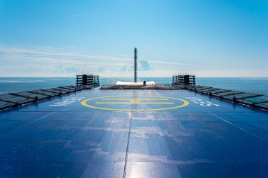 Denizde bir feribotun üstündeki helikopter güvertesi. Sarı işaretli mavi.