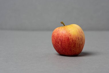 Gri arkaplanda kırmızı ve sarı elma.