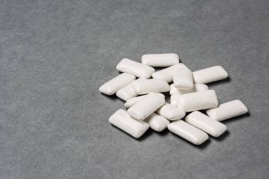 Gri arkaplanda sakız çiğnemek.