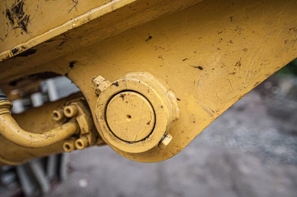 Detail of the base mount of a hydraulic cylinder on an excavator.