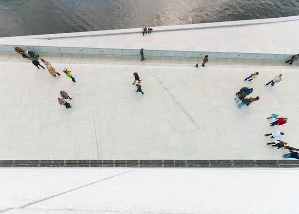 Beyaz beton bir yolda yürüyen insanlara bakıyorum..