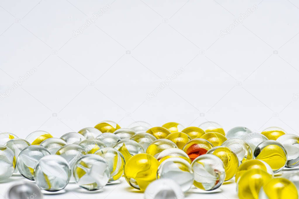 Yellow, white and red glass marbles on a table.