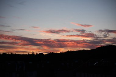 Güneş batarken kırmızı bulutlar parladı..