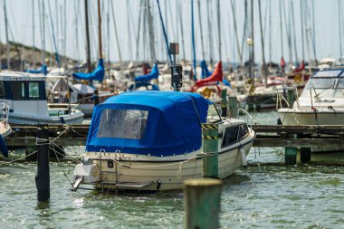 Mavi gölgelikli küçük motorlu tekne marinaya yanaştı.