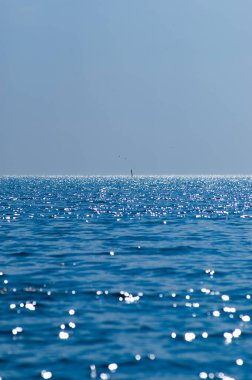 parlak güneş ışığı açık okyanus suyuna yansıyor.