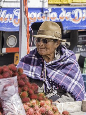Saquisili, Ecuador - May 2, 2019 - indigenous lady selling in the Saquisili market in the Cotopaxi region of Ecuador, South America clipart