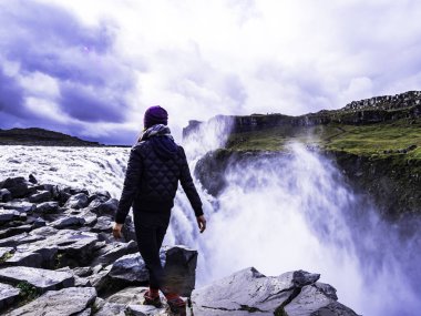 Kuzey Izlanda 'da Selfoss Şelalesi kenarında yürüyen kadın gezgin