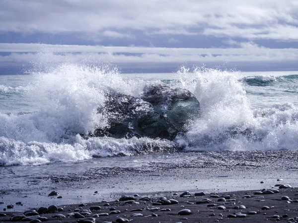 Ocean wave clashing at an iceberg on Diamond Beach in Iceland — Stock Photo, Image