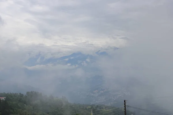 雲に覆われた山々と都市は 山の上で見ることができます シッキム インド — ストック写真