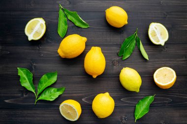 Taze limon ve limon yaprakları koyu ahşap arka plan üzerinde.