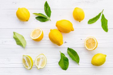 Taze limon ve beyaz ahşap zemin üzerine limon yaprakları.