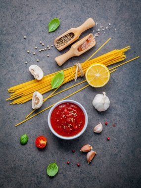 Karanlık taş zemin üzerine ince spagetti. Sarı İtalyan makarna malzemelerle. İtalyan gıda ve menü kavramı.