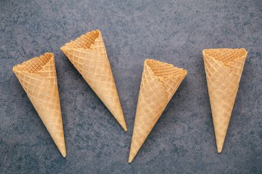 Dondurma külahları koyu taştan arka planda toplanmış. Tatlı için kopyalama alanı olan gevrek dondurma külahı..