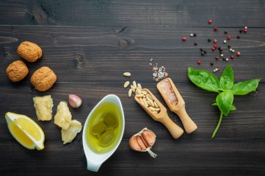 Koyu ahşap zemin üzerine yeşil pesto sos için malzemeler.