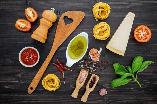 De pasta op zwarte houten achtergrond. Gele Italiaanse pasta met — Stockfoto