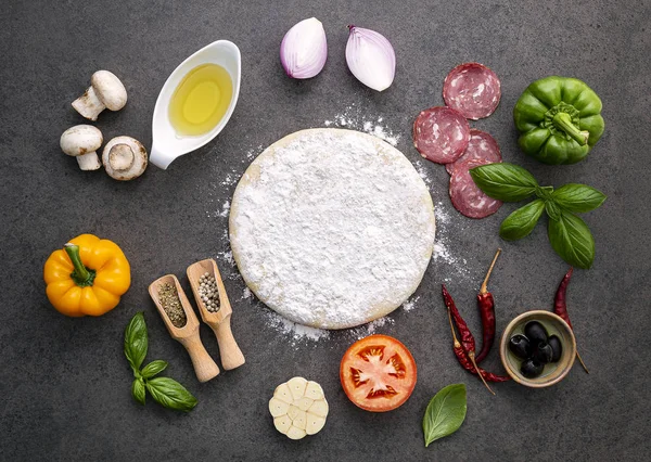 Gli ingredienti per la pizza fatta in casa su sfondo pietra scura . — Foto Stock