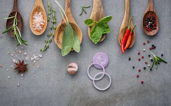 Varie spezie ed erbe aromatiche in cucchiai di legno. Spezie di posa piatta in — Foto Stock