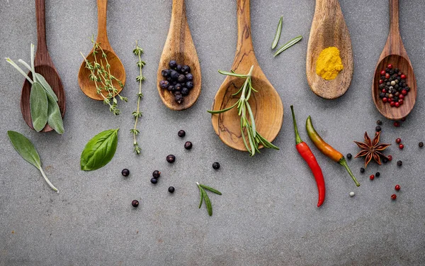 Varie spezie ed erbe aromatiche in cucchiai di legno. Spezie di posa piatta in — Foto Stock