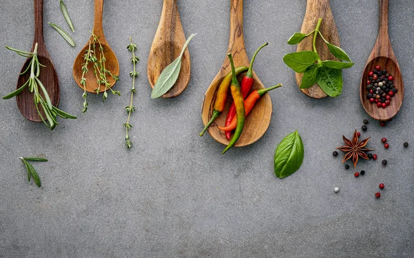 Varie spezie ed erbe aromatiche in cucchiai di legno. Spezie di posa piatta in — Foto Stock