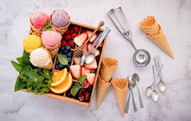 Konilerde çeşitli dondurma aromalı ve beton arka planda tahta kutuda böğürtlen. Yaz ve Tatlı menü kavramı. 