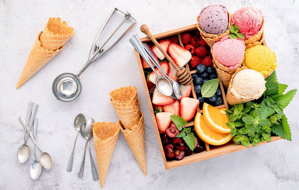Various of ice cream flavor in cones with berries in wooden box setup on concrete background . Summer and Sweet menu concept.
