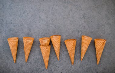 Dondurma külahları koyu taştan arka planda toplanmış. Tatlı için kopyalama alanı olan gevrek dondurma külahı..